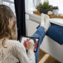 Femme qui se réchauffe près d'un radiateur électrique
